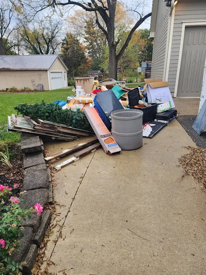 Dumpster being loaded with debris for 12 Yard Dumpster Rental in University